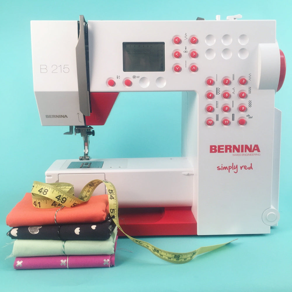 Bernina sewing machine with colorful fabric and measuring tape on a turquoise background