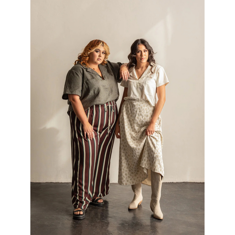 To women standing next to each other wearing collared shirts