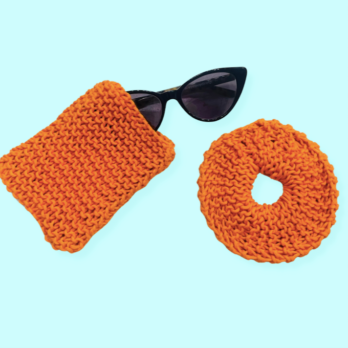 Image of Summer knitting projects for Knitting 101: Orange sunglasses case with black sunglasses peeking out, orange scrunchy next to it on light blue blackground 